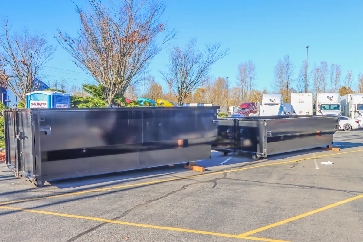 Professional dumpster rental service with roll-off container on residential driveway in Somersworth